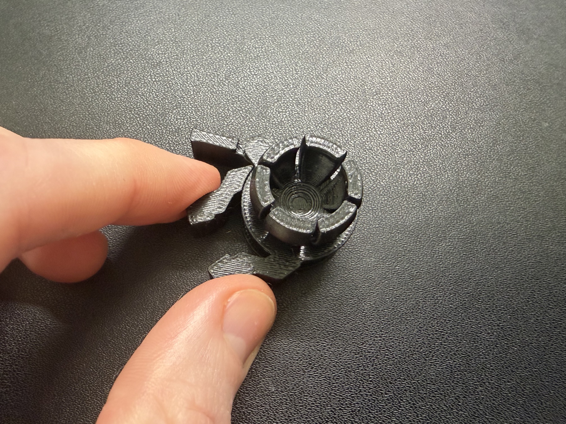 A hand squeezing a printed jaw component to free the moving jaws.