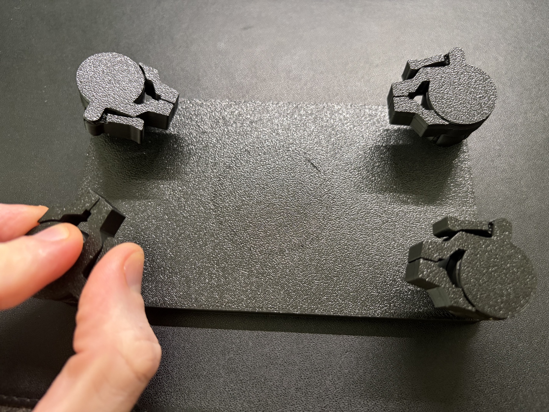 A hand fitting one of the four jaw components onto a ball joint on the jig.