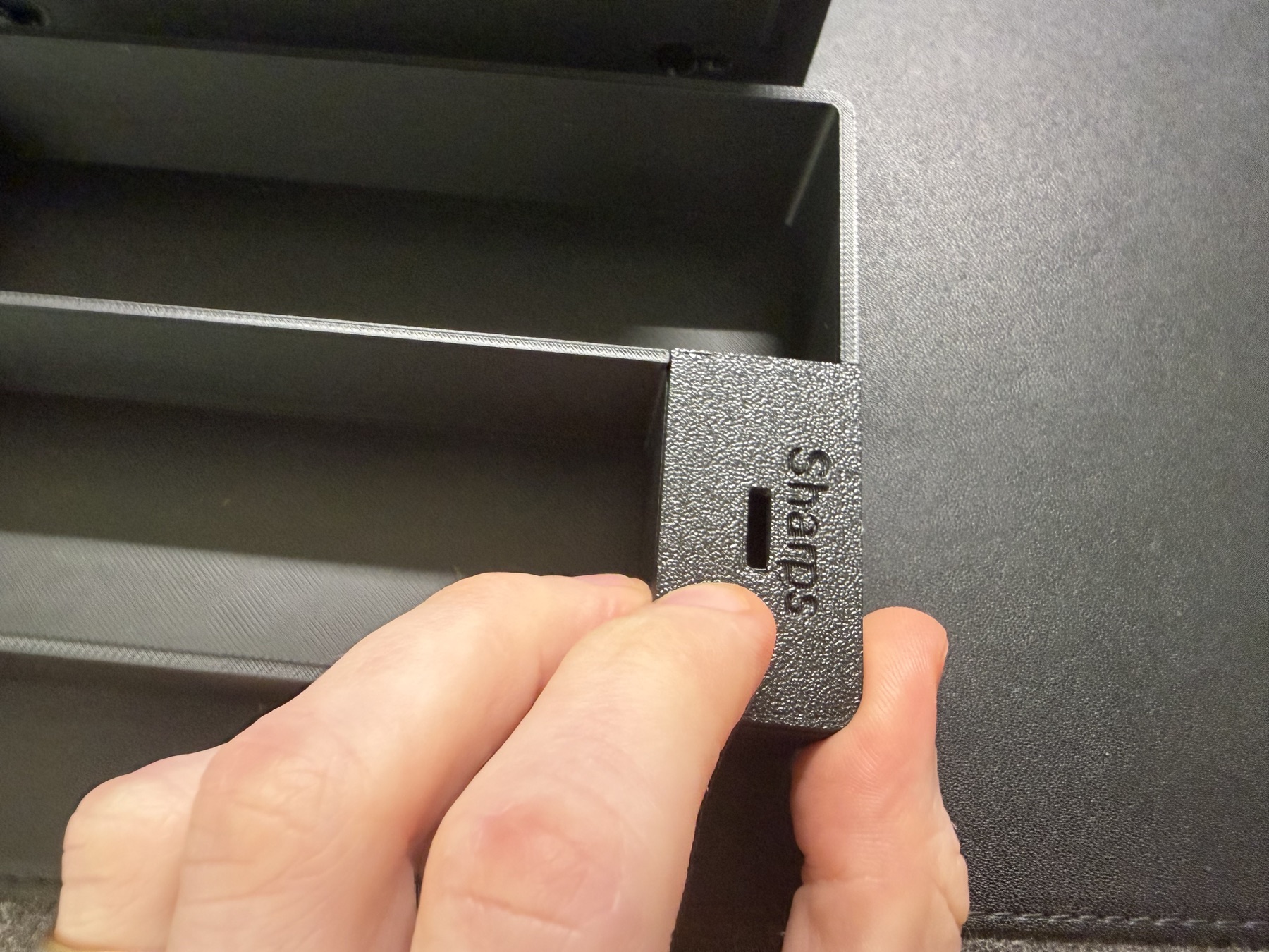 A hand placing the small sharps lid into the tool tray compartment.